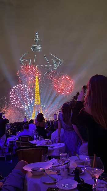 Cientos de drones formaron la silueta de la Torre Eiffel en el cielo de París durante el espectáculo nocturno que la familia presenció desde el restaurante Girafe