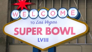 Un letrero brillante estilo Las Vegas, blanco y amarillo, con la inscripción "WELCOME TO Las Vegas SUPER BOWL LVIII" en letras rosas y moradas, y una estrella roja en la parte superior