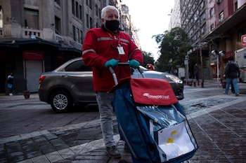 Un adulto mayor durante su jornada laboral como cartero, durante la cuarentena obligatoria decretada ante el avance de la COVID-19, en Santiago (Chile). EFE/Alberto Valdés/Archivo
