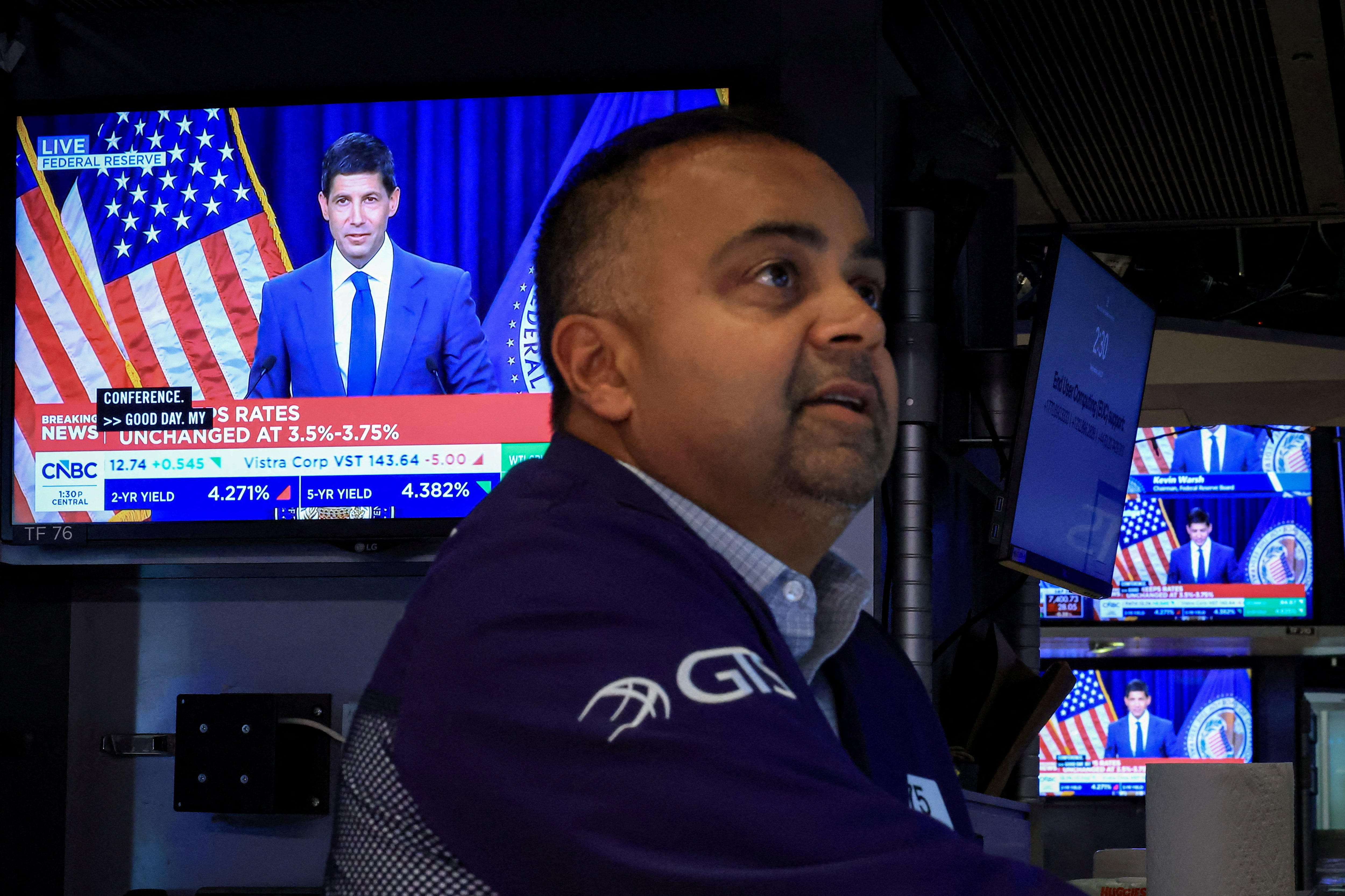 FOTO DE ARCHIVO: Un operador trabaja mientras en pantallas se transmite una conferencia de prensa del presidente de la Reserva Federal de Estados Unidos, Kevin Warsh, tras el anuncio de las tasas de interés de la Fed, en el parqué de la Bolsa de Nueva York (NYSE) en la ciudad de Nueva York, EE. UU., el 29 de julio de 2026. REUTERS/Brendan McDermid/File Photo/File Photo