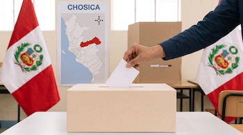 Una mano introduce una cédula blanca en una urna de cartón flanqueada por dos banderas del Perú y un mapa con la palabra Chosica.
