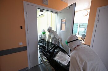 Especialistas médicos transportan el cuerpo