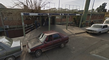 Fachada del Hospital Interzonal Doctor Diego Paroissen con un cartel en el acceso, personas cerca de la entrada y vehículos estacionados.