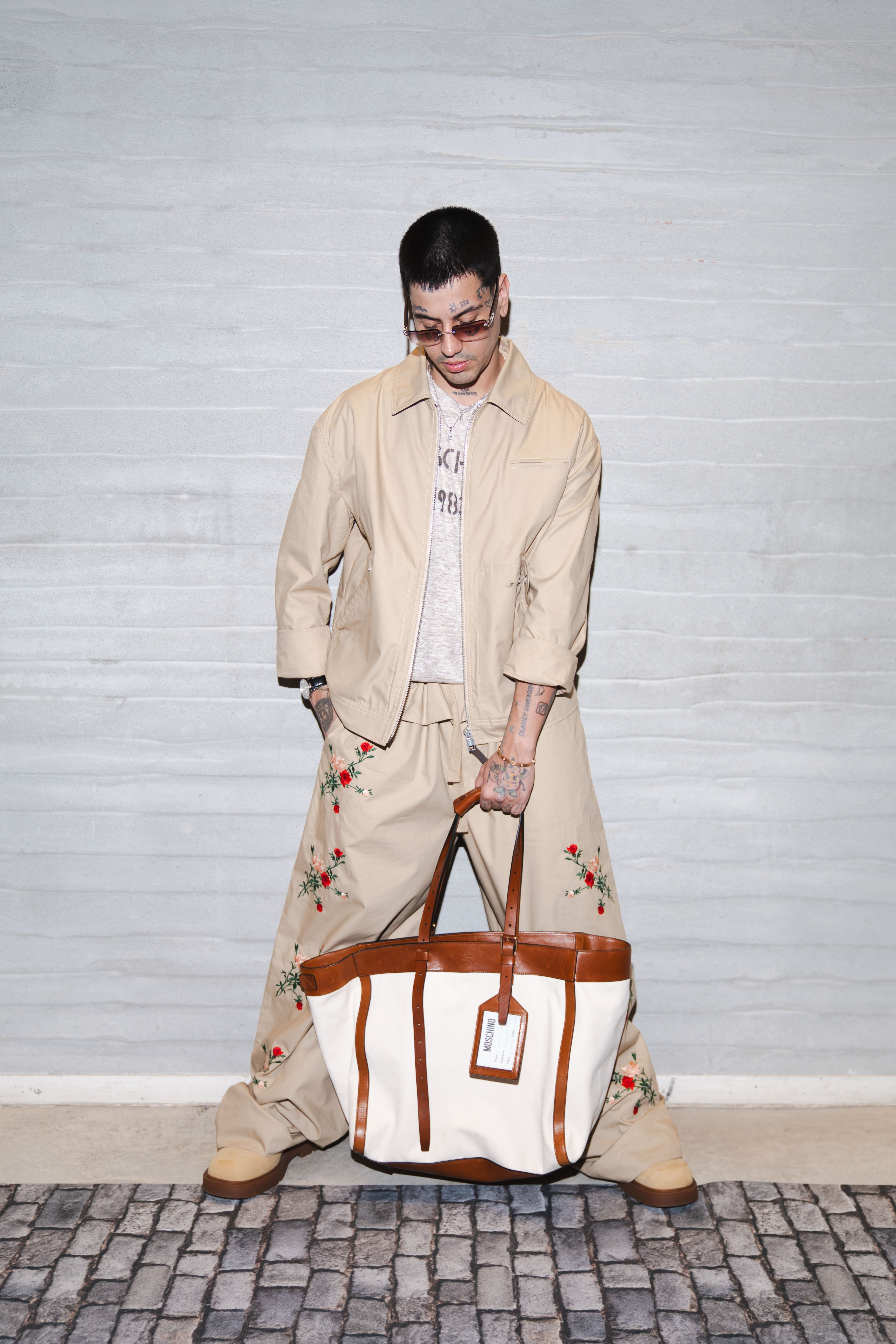 El rapero argentino Duki asiste a la Semana de la Moda de Milán luciendo un conjunto bordado y un bolso Moschino, destacando su estilo único