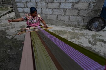 Juana Pérez, usa un telar
