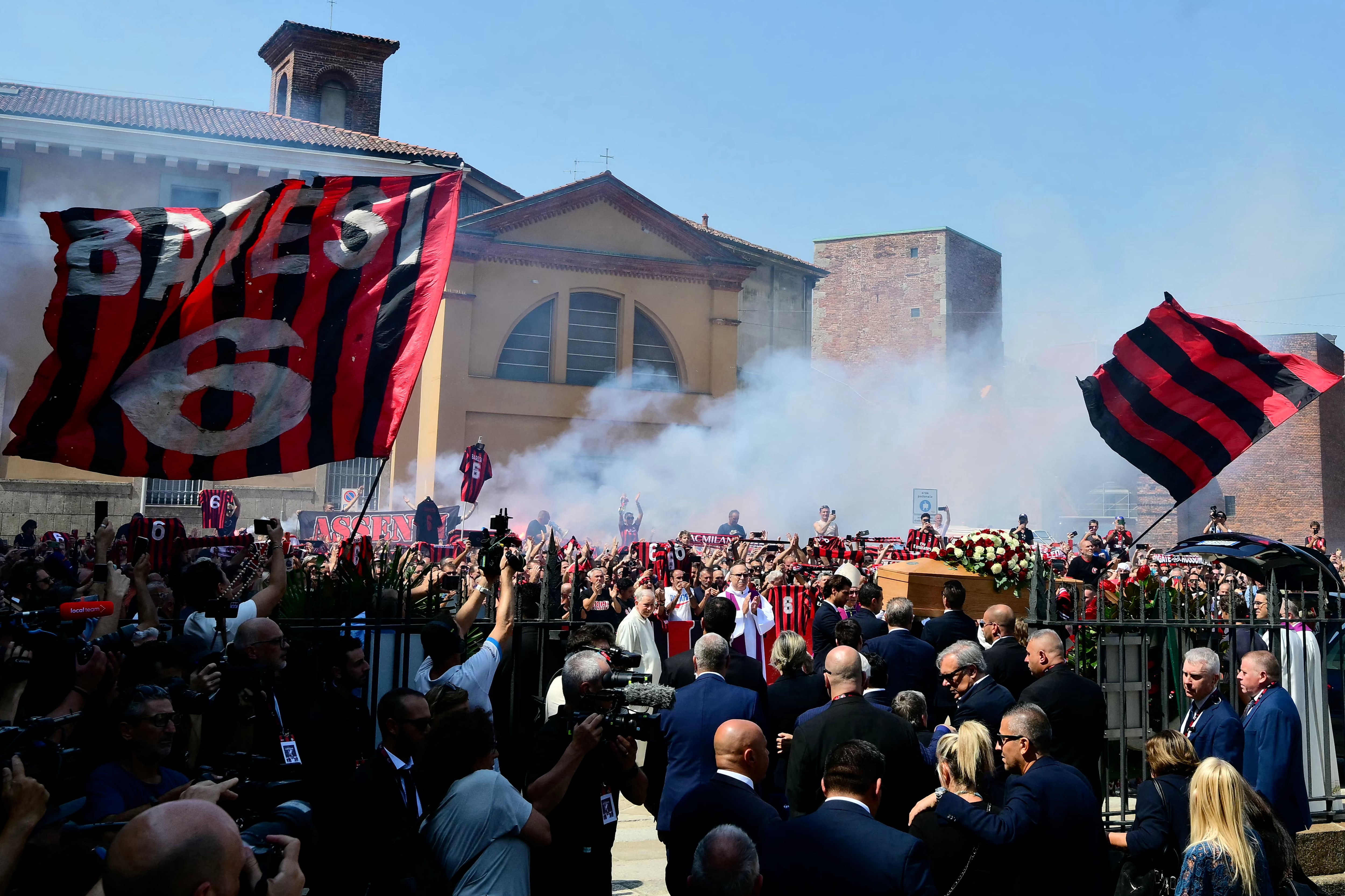 Los seguidores del AC Milan reaccionaron mientras los portadores del féretro trasladan el ataúd del fallecido futbolista del AC Milan, Franco Baresi, a las afueras de la Basílica