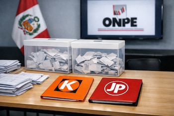 Mesa de madera con urnas transparentes llenas de papeles, pilas de documentos, una carpeta naranja con una K blanca y una carpeta roja con JP, bandera peruana y logo ONPE en pantalla.