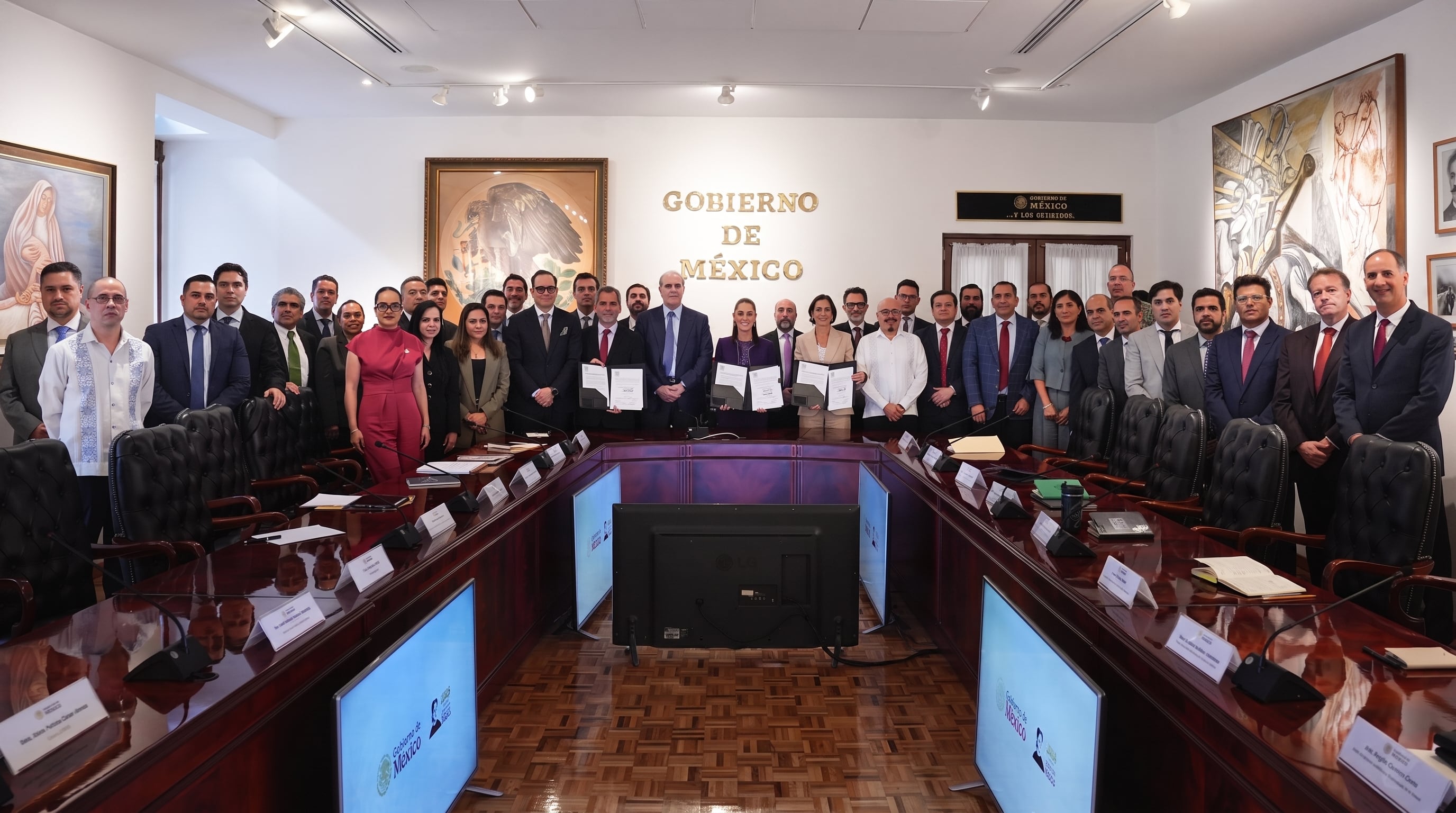 Integrantes del Gobierno de México sostienen carpetas con acuerdos firmados tras una reunión de trabajo celebrada en una sala de conferencias. (Imagen Ilustrativa Infobae)