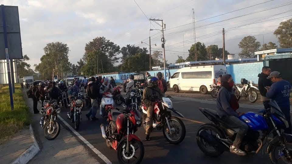 Un grupo de motociclistas se congrega sobre el asfalto de una vía junto a varios peatones y otros vehículos. (Redes Sociales)