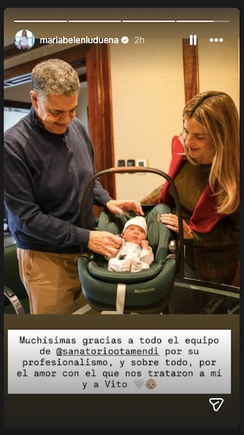 Jorge Macri y María Belén Ludueña miran sonrientes a su bebé Vito, quien está en un asiento de seguridad infantil verde oscuro. Ambos lo rodean con cariño
