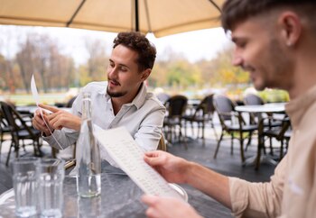 Dos personas mirando la carta de un restaurante. (Magnific)