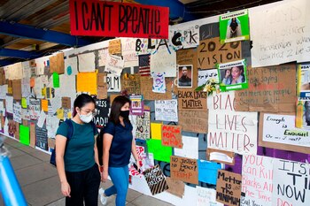 Pedestrians pass by a picture of George Floyd (C) as well as signs supporting the Black Lives Matter movement, across the street from Lafayette Park near the White House, in Washington, DC, USA, 11 June 2020. EFE/MICHAEL REYNOLDS