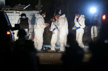 Oficiales forenses trabajan en