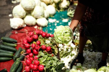 Una mujer vende verduras en