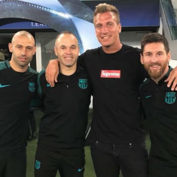 Javier Mascherano, Andrés Iniesta, Maxi López y Lionel Messi posan abrazados y sonrientes frente a una pared con logotipos deportivos