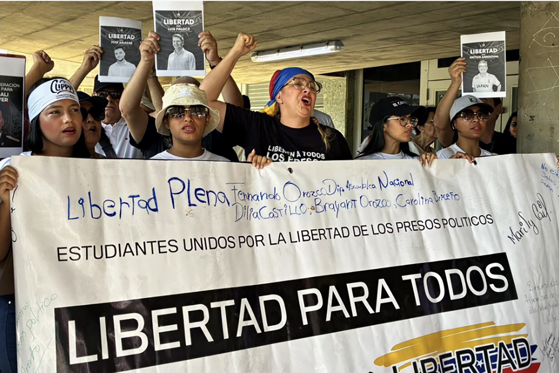 Un grupo de estudiantes venezolanos protesta con pancartas y lemas, exigiendo la libertad plena de los presos políticos, incluyendo figuras como Fernando Orozco y Dilia Castillo.
