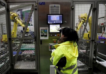 Un trabajador opera brazos robóticos