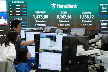Operadores observan monitores cerca de una pantalla en donde se despliega el Índice Compuesto de Precios de Acciones de Corea (KOSPI), en la sede del Banco Hana, el miércoles 15 de abril de 2026, en Seúl, Corea del Sur (AP Foto/Ahn Young-joon)