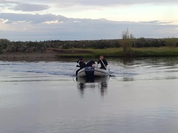 Personal del Grupo Especial de Rescate y Salvamento junto a buzos de Prefectura Naval durante las tareas de rastrillaje en el cauce donde desaparecieron los dos hermanos