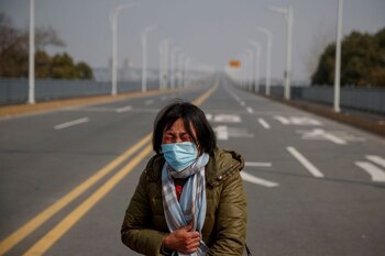 Una madre reacciona mientras le pide a la policía que permita a su hija pasar un puesto de control para su tratamiento contra el cáncer después de llegar desde la provincia de Hubei al puente del río Yangtsé en Jiujiang, provincia de Jiangxi (China), mientras el país se ve afectado por un brote de un nuevo coronavirus, el 1 de febrero, 2020. (REUTERS)
