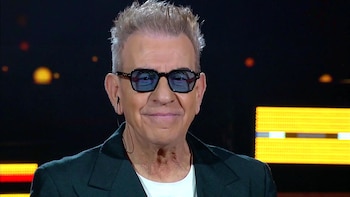 Retrato de Miguel Ángel Rodríguez con gafas de cristales azules, chaqueta oscura, camiseta blanca y luces de fondo