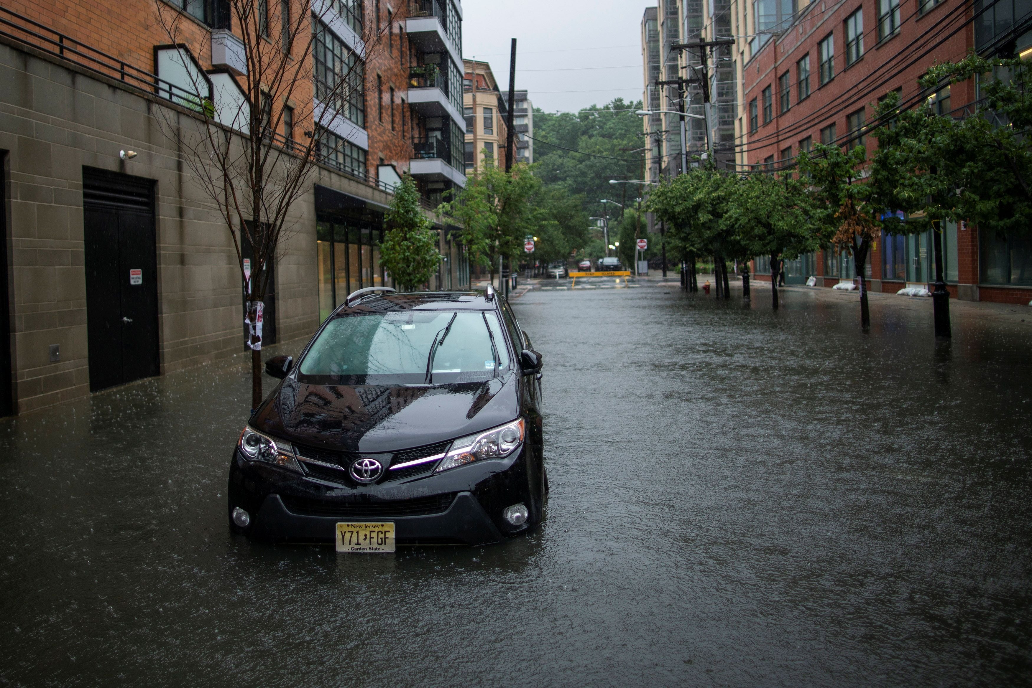 A car is seen on a flooded street as Tropical Storm Elsa passes through Hoboken, New Jersey, U.S., July 9, 2021. REUTERS/Eduardo Munoz