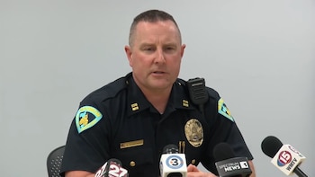 Un oficial de la policía de Madison con uniforme habla frente a varios micrófonos de medios de comunicación