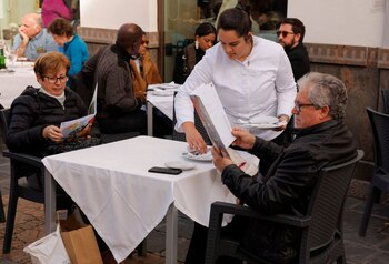 Un camarero prepara la mesa,
