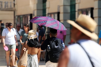 Imagen de archivo de viandantes soportando las altas temperaturas por las calles de Málaga. (Álex Zea/Europa Press)