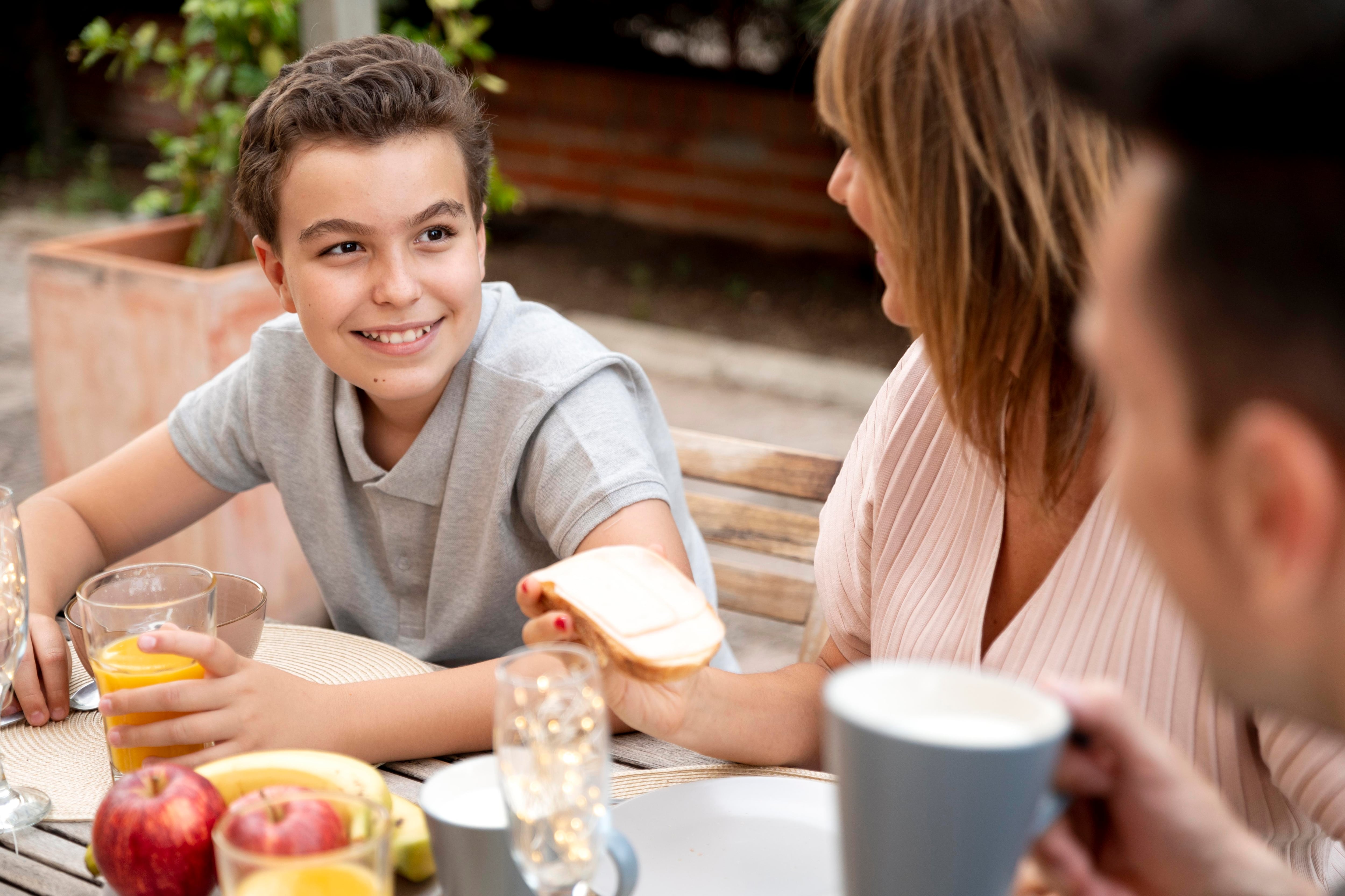 Un preadolescente desayuna con sus padres (Magnific)