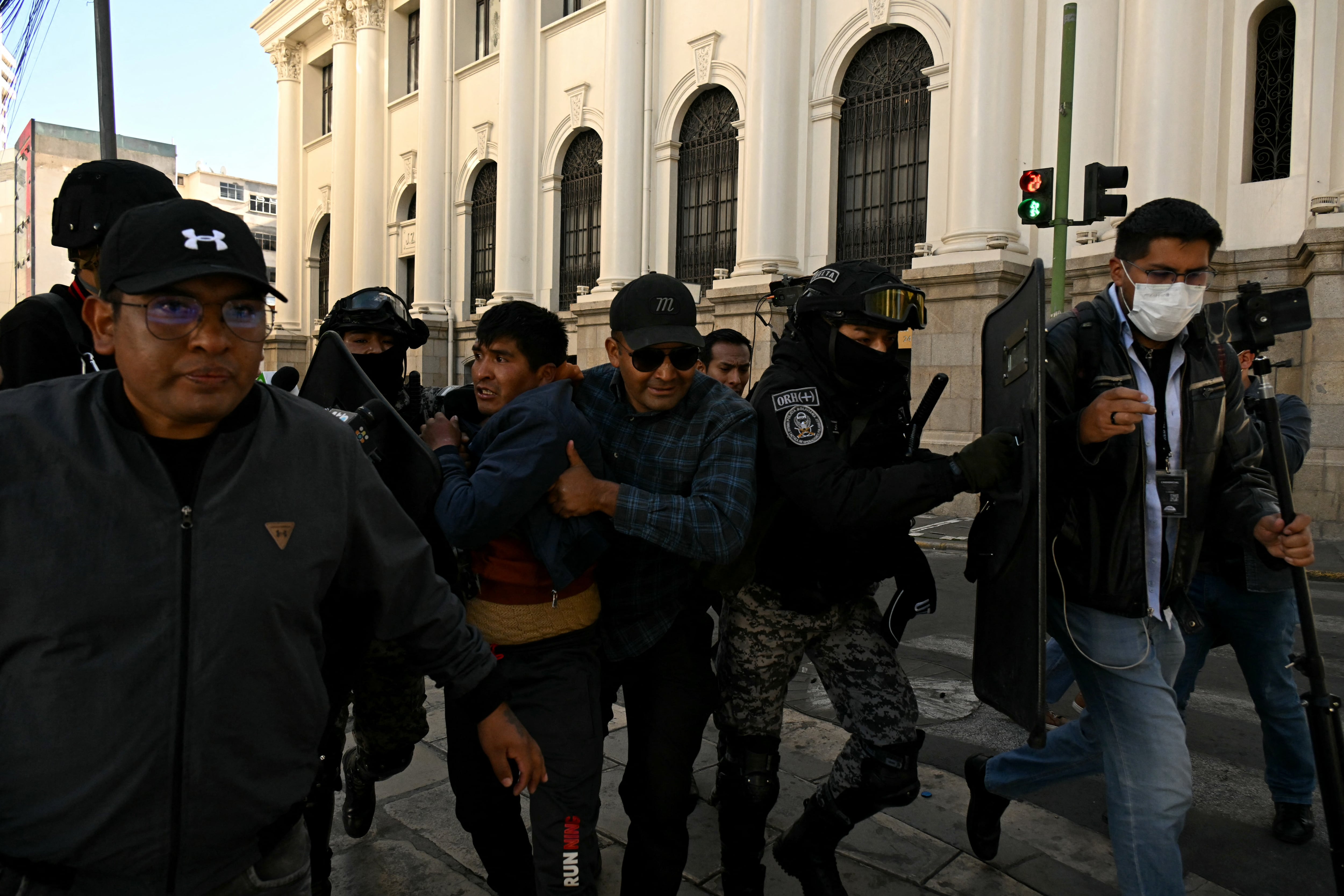 Policías detienen a un manifestante minero tras los enfrentamientos registrados durante una protesta en La Paz (AFP)