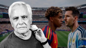 Hombre mayor en primer plano en blanco y negro, dos futbolistas borrosos, cancha de fútbol, tribunas llenas y pantalla gigante de estadio