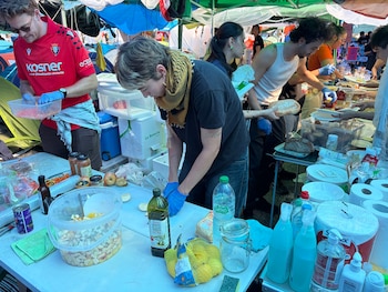 Algunos de los acampados preparan comida (Infobae España)