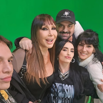Cinco personas sonríen juntas y posan para una fotografía frente a una pantalla verde de croma