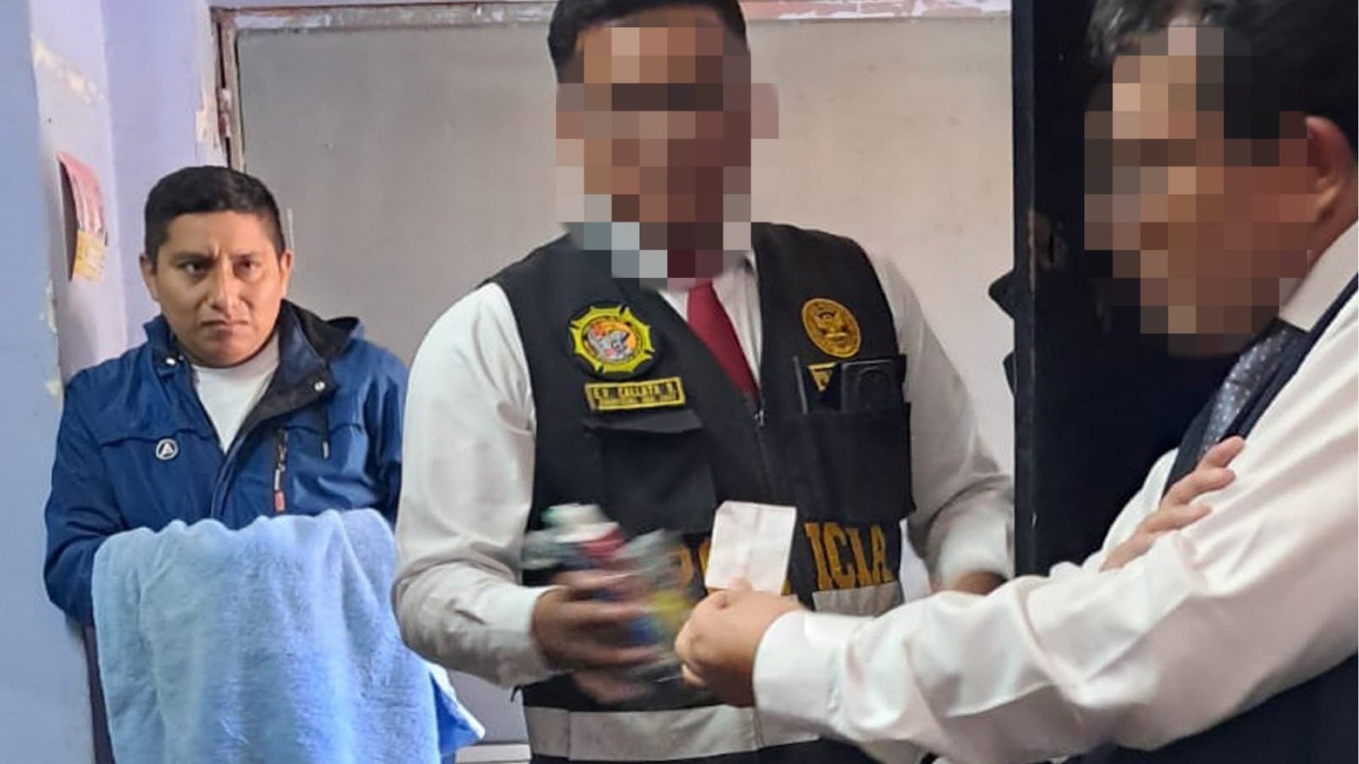 Un agente del INPE permanece junto a oficiales de la Policía Nacional del Perú tras ser detenido por intentar ingresar dinero en efectivo y chips telefónicos al penal de Arequipa. (X/@INPE)