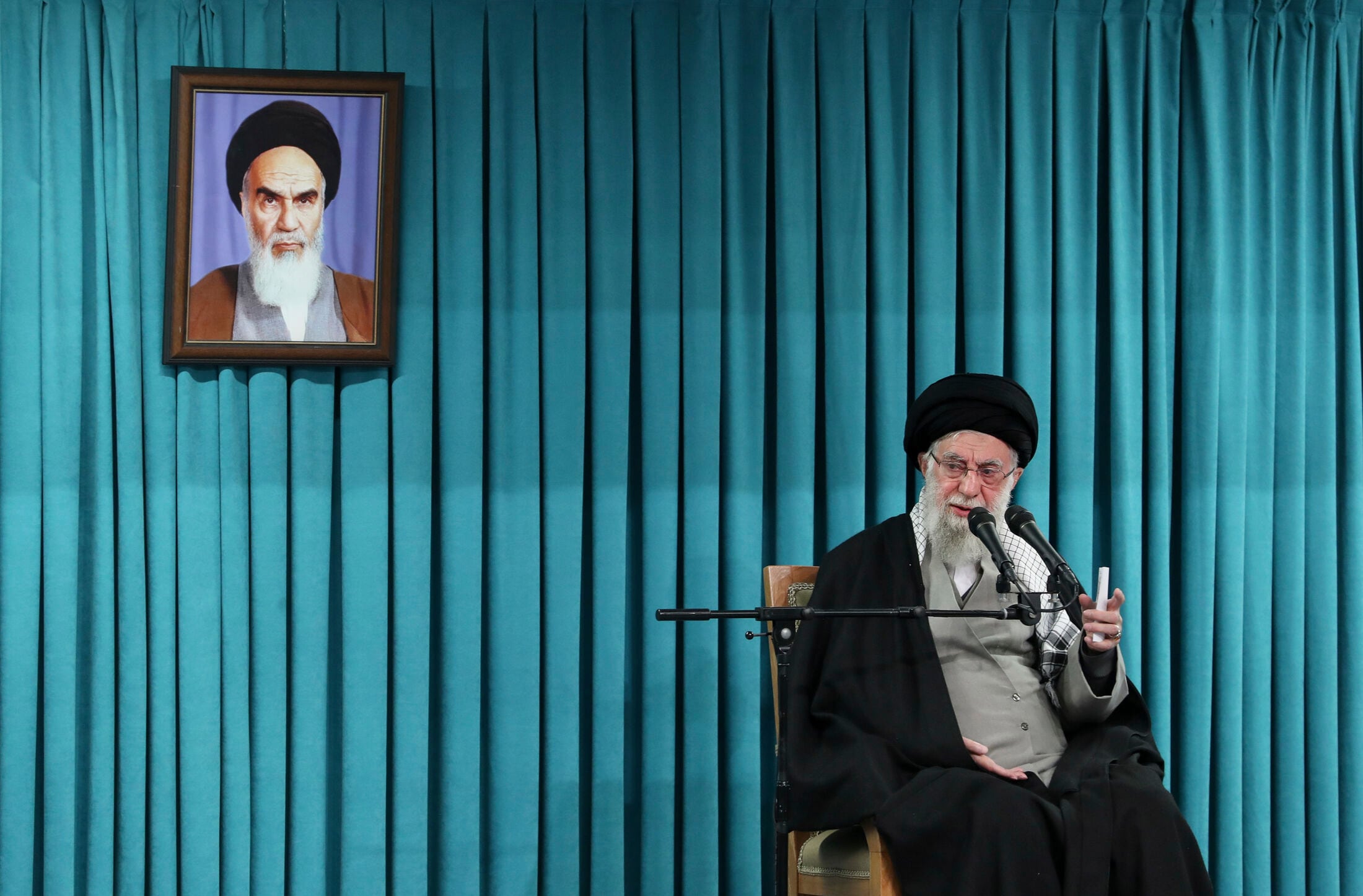 El ayatollah Ali Khamenei se dirige a funcionarios en Teherán, bajo el retrato de Jomeini, durante una ceremonia oficial en marzo de 2025 (AP/Archivo)