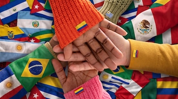 Manos superpuestas al centro con mangas de colores y parches de banderas sobre un fondo con múltiples banderas latinoamericanas.