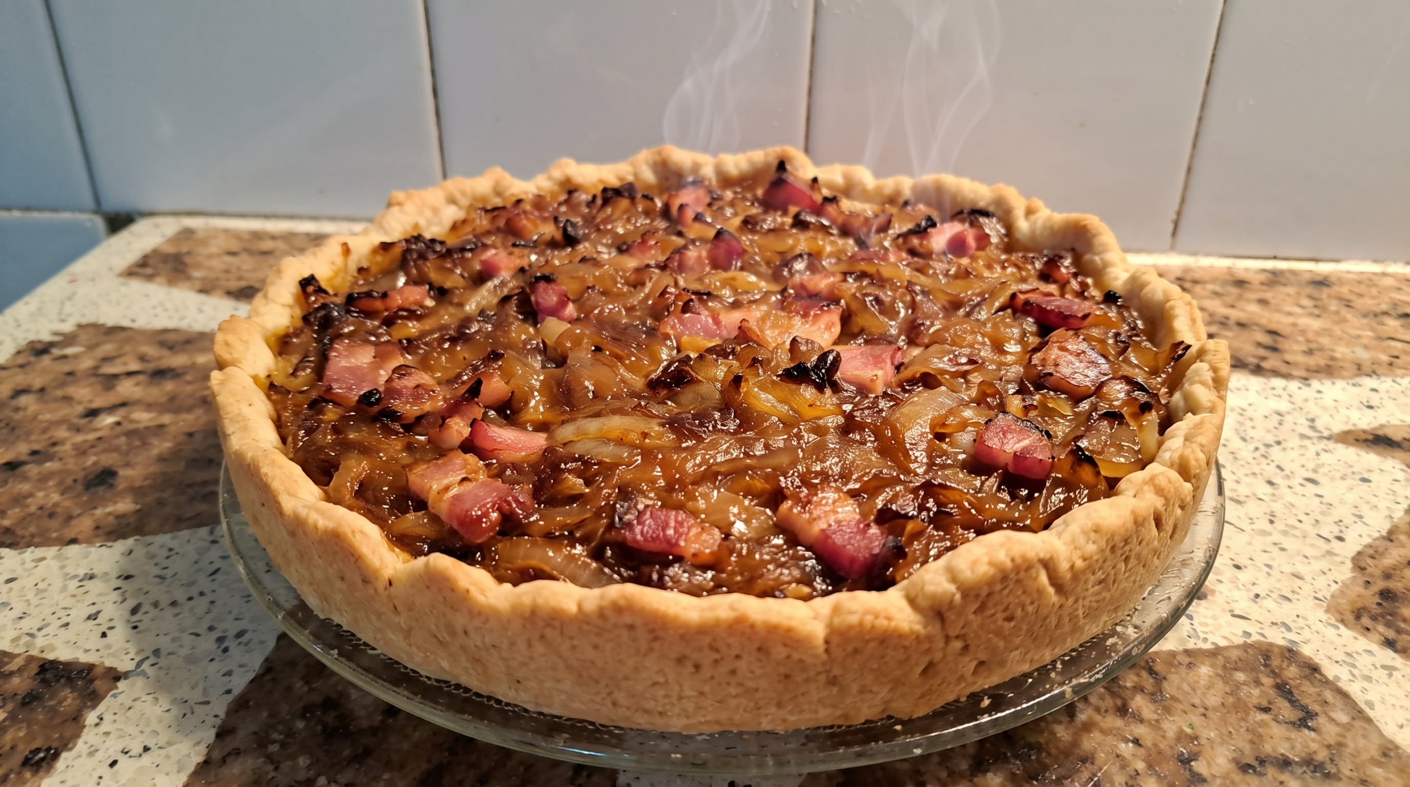 La receta de tarta de cebollas caramelizadas con panceta se prepara con masa hojaldrada, huevos, crema y queso (Imagen Ilustrativa Infobae)