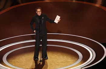 Smoking negro de solapas anchas, camisa oscura y gafas de marco oscuro en ceremonia de premiación (REUTERS/Carlos Barria)