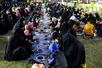 Muslims gather for a free public Iftar meal organized by a charitable organization that cares for people in need during the holy fasting month of Ramadan, in Najaf, Iraq March 22, 2024. REUTERS/Alaa al-Marjani