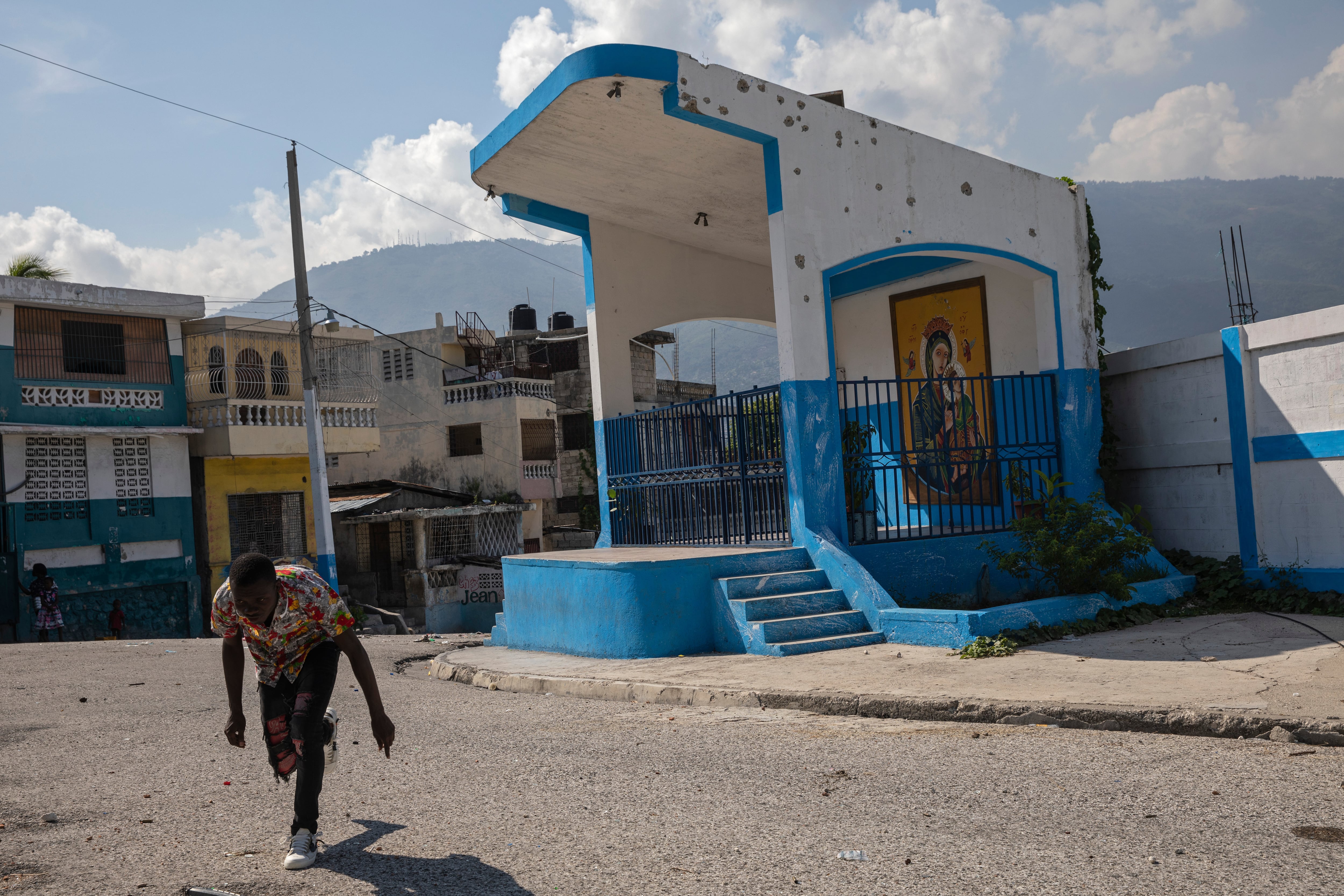 Un hombre al cruzar una calle con barricadas en el vecindario Bel Air de Puerto Príncipe, Haití, el 25 de septiembre del 2021 (AP foto/Rodrigo Abd)