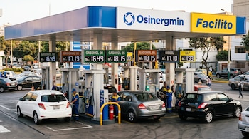 Surtidores de combustible con carteles digitales de precios, vehículos estacionados, trabajadores y letreros de Osinergmin y Facilito.
