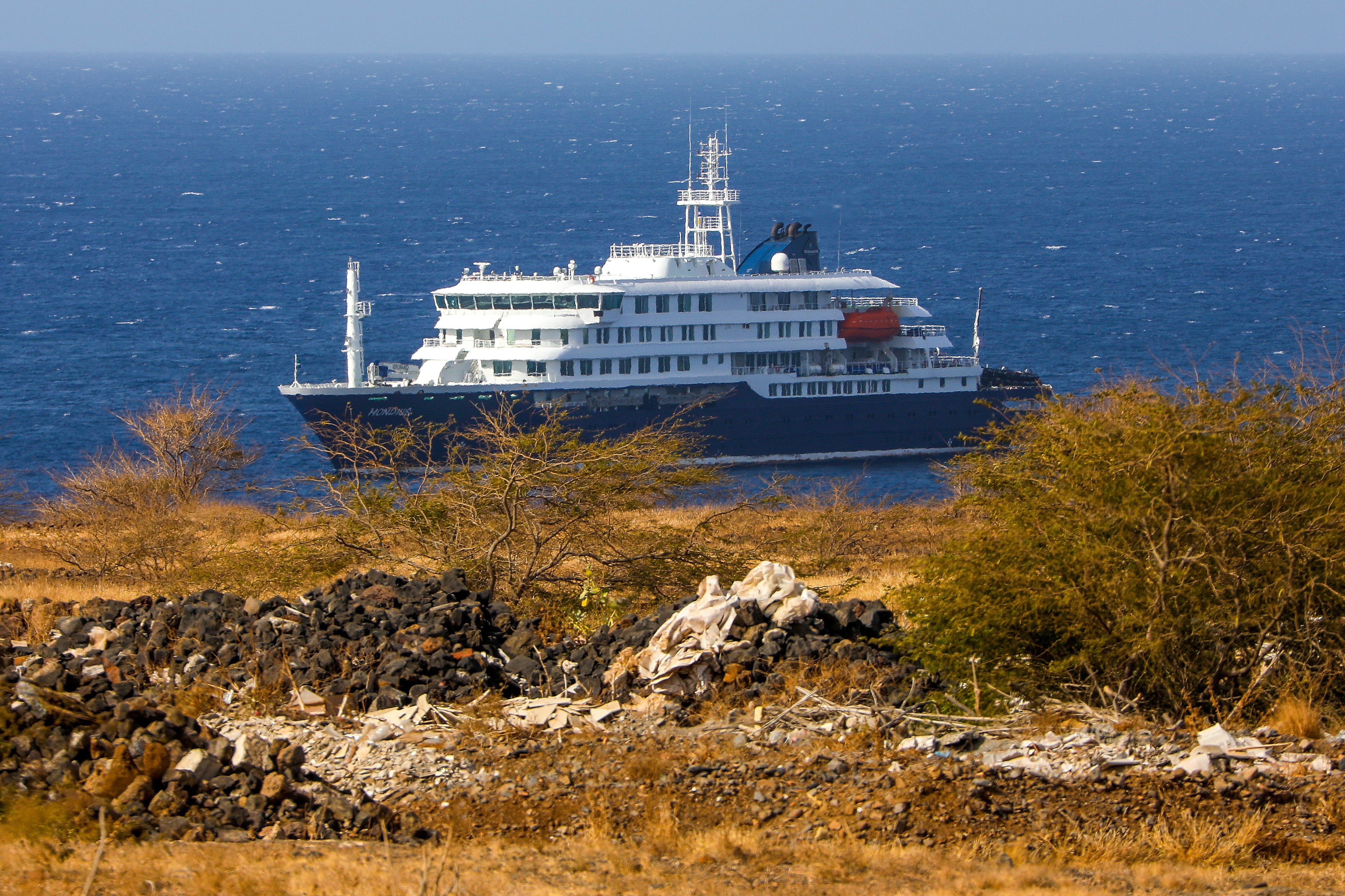 El crucero holandés MV Hondius (atrás), anclado frente a la costa de la ciudad de Praia en la isla de Santiago, Cabo Verde, este lunes 4 de mayo de 2026. (EFE/EPA/ELTON MONTEIRO)