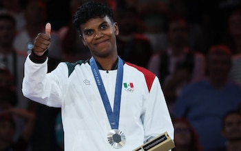 Judocas fazem sinal de positivo ao posar com as medalhas olímpicas conquistadas nos Jogos de Paris 2024.