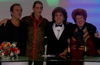 Urdampilleta, Tortonese, Gasalla y Nelly Lainez posan sonrientes detrás de una mesa con dos premios dorados y un ramo de flores