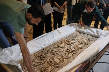 Museum employees unpack a carved stone panel after Syrian authorities unveiled antiquities returned from France at the National Museum in Damascus, Syria, Wednesday, July 8, 2026.(AP Photo/Ghaith Alsayed)