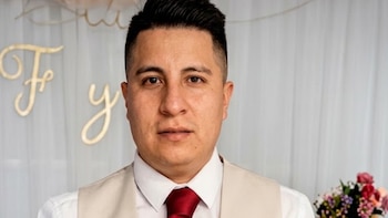 Retrato de un hombre vestido con camisa blanca, chaleco beige y corbata roja sobre un fondo con cortinas claras