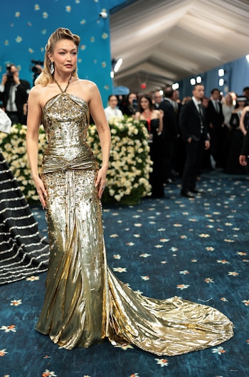El vestido halter dorado, cubierto de lentejuelas, reafirmó la preferencia de Gigi Hadid por los detalles brillantes y la sofisticación en la alfombra azul (REUTERS/Mario Anzuoni)