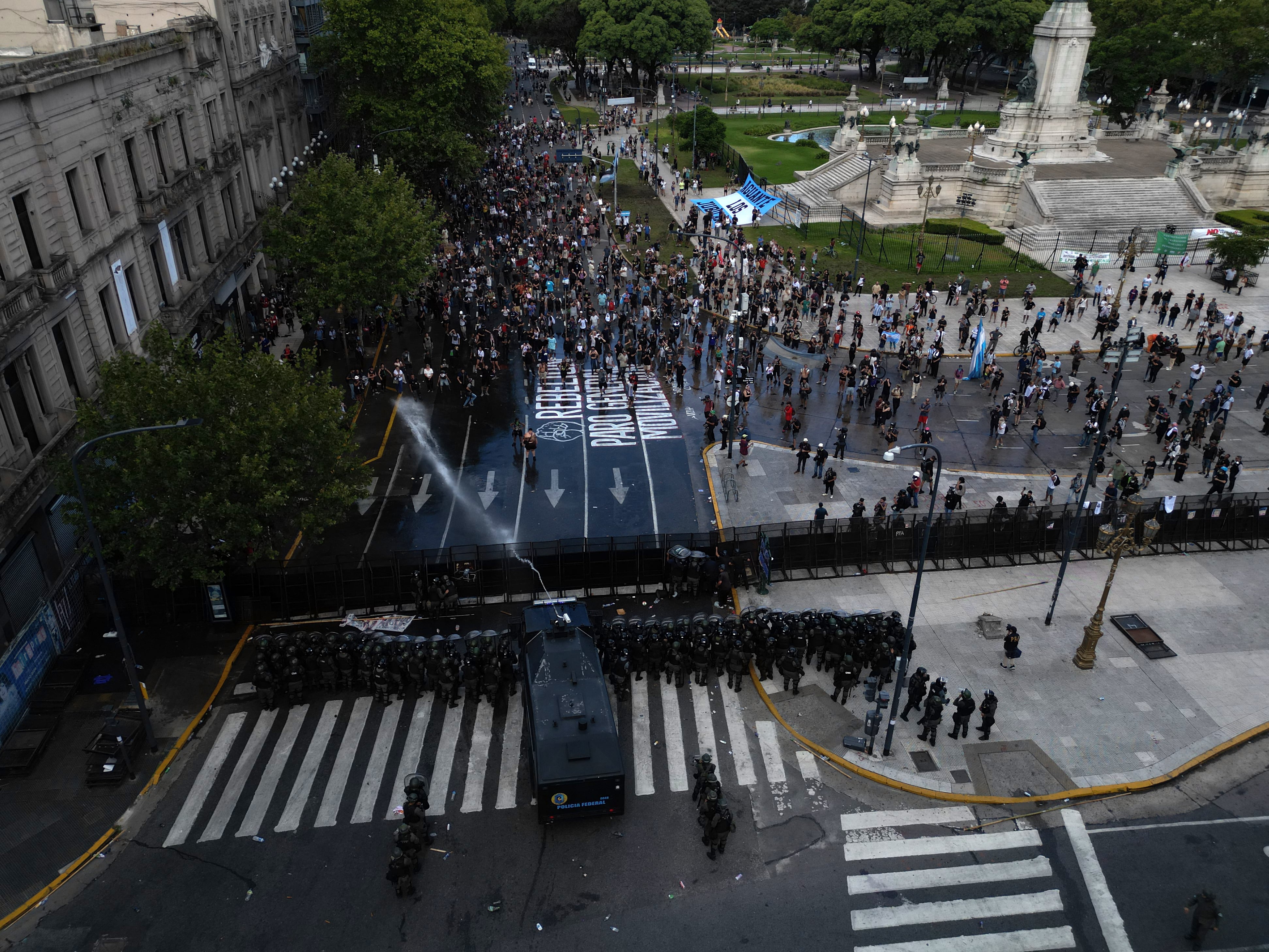 El avance de la policía con camiones hidrantes y uso de gas obligó a desalojar a los manifestantes frente al Congreso durante la protesta contra la reforma laboral (Photo by TOMAS CUESTA / AFP)