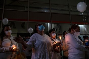 Personal de salud sostiene velas